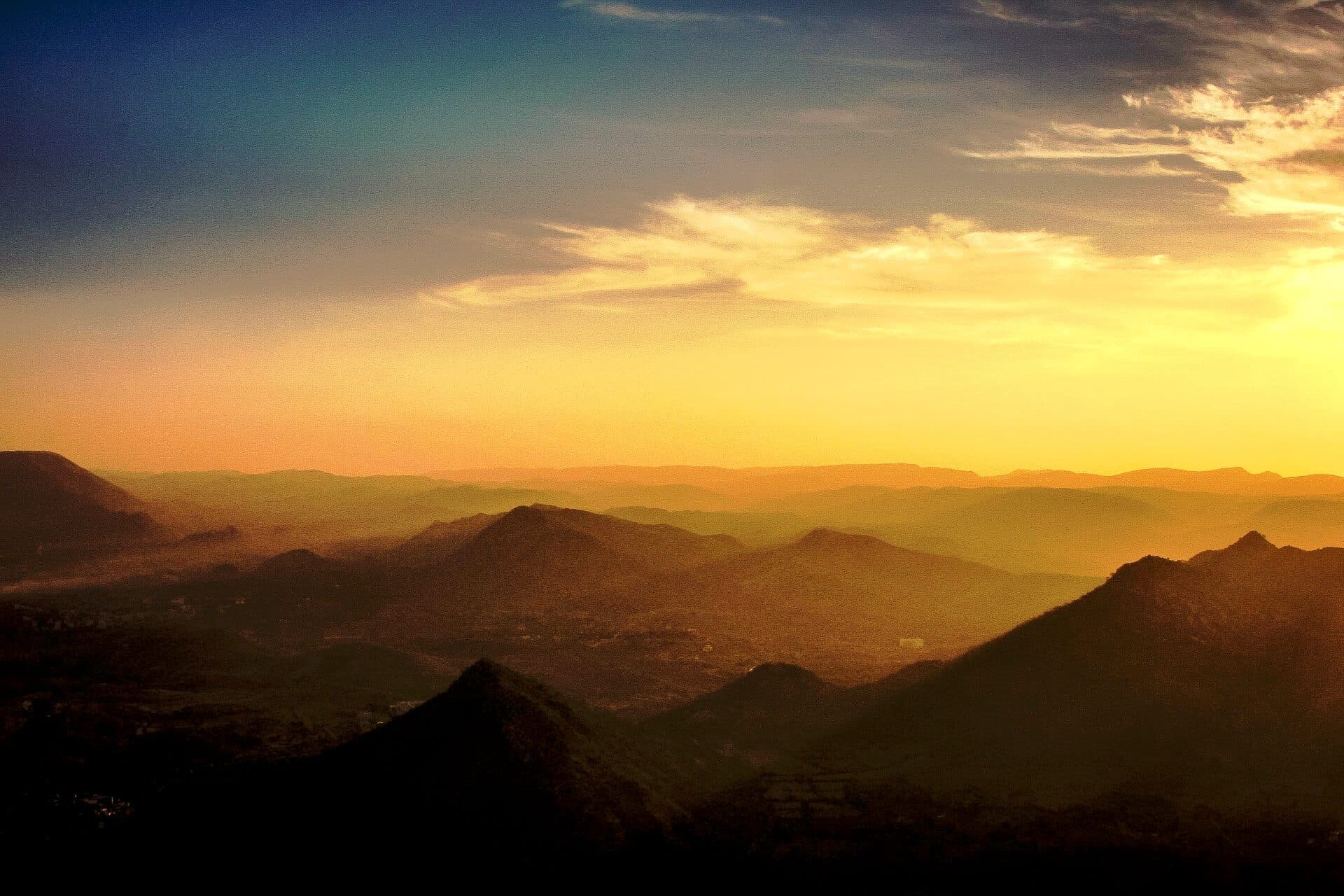 Ridge after ridge of the Aravallis fading into haze at sunset, seen from the hills above Udaipur